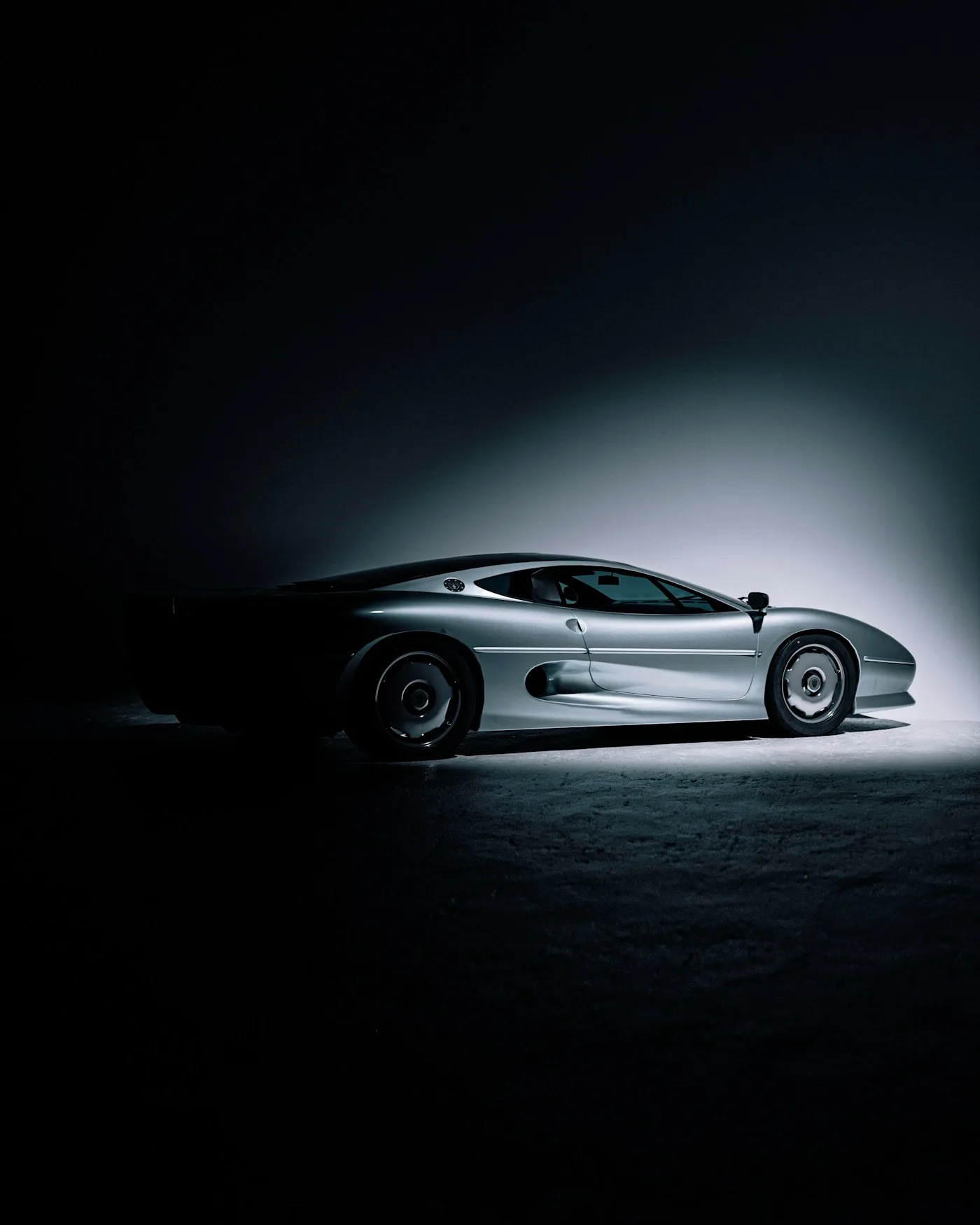Voiture de sport argentée sous un éclairage cinématique